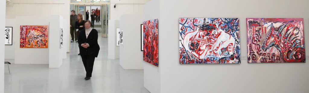 Artworks by Mikkel Urup displayed in a modern gallery space, featuring abstract and colorful paintings.