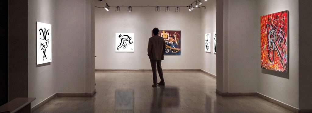 "Artworks by Mikkel Urup displayed in a well-lit gallery, with viewers engaging with the pieces.